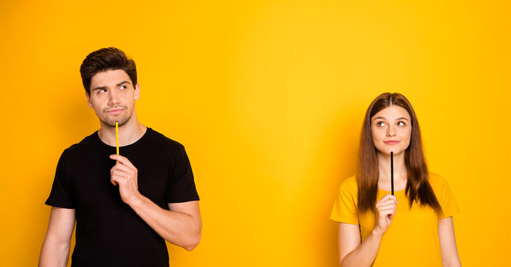 Ein Mann und eine Frau stehen vor einer gelben Wand und grübeln - Symbolbild für das Thema Entscheidungen treffen